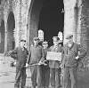 [Group portrait of five railway workers holding a sign "Not Movable" and a large wrench, Broadstone, Dublin]