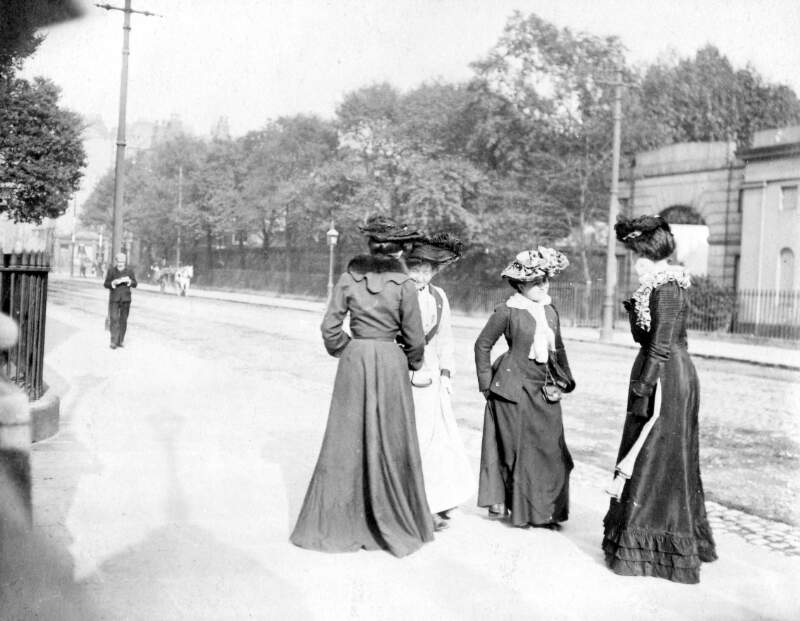 [Four women standing at the gate to UCD, Earlsfort Terrace]