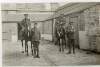 [Two unidentified officers mounted on horses and two unidentified officers standing alongside horses in stable yard, full length, front facing portrait]