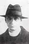 [Éamon De Valera, dressed in a clerical collar and wearing a hat, front facing, head and shoulder length portrait]