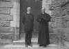 [Lusitania disaster, Cobh, Co. Cork : two clergymen standing outside wooden door, probably a church]